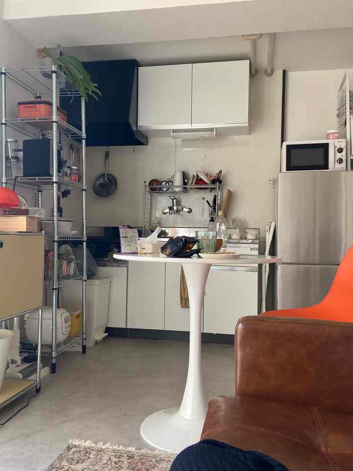 A cozy 1DK kitchen in white and orange tones featuring mid-century modern furniture