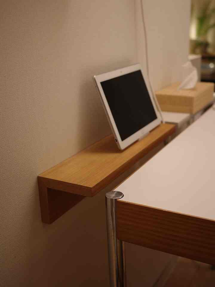 ベージュの壁、ナチュラルな棚、白いダイニングテーブルが配置された清潔感のあるダイニング空間