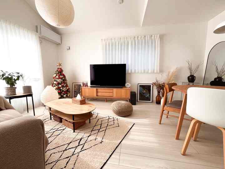 白とナチュラルカラーのリビング、クリスマスツリーと木製家具が温かみのある雰囲気のインテリア