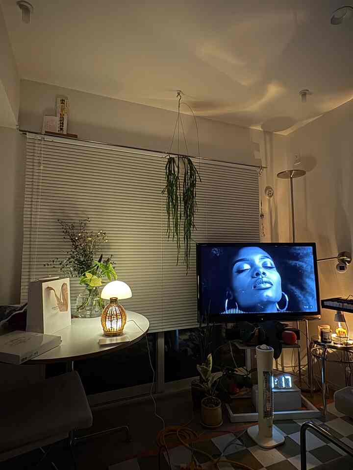 白を基調としたリビングルーム、木目調の照明を配した二人暮らし向けのミッドセンチュリーモダンな雰囲気のあるインテリア