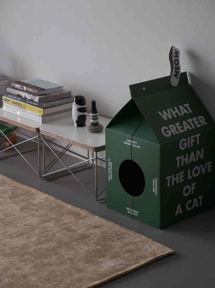 Gray-toned living room featuring a mustard rug and green cat pet house with a natural, cozy atmosphere