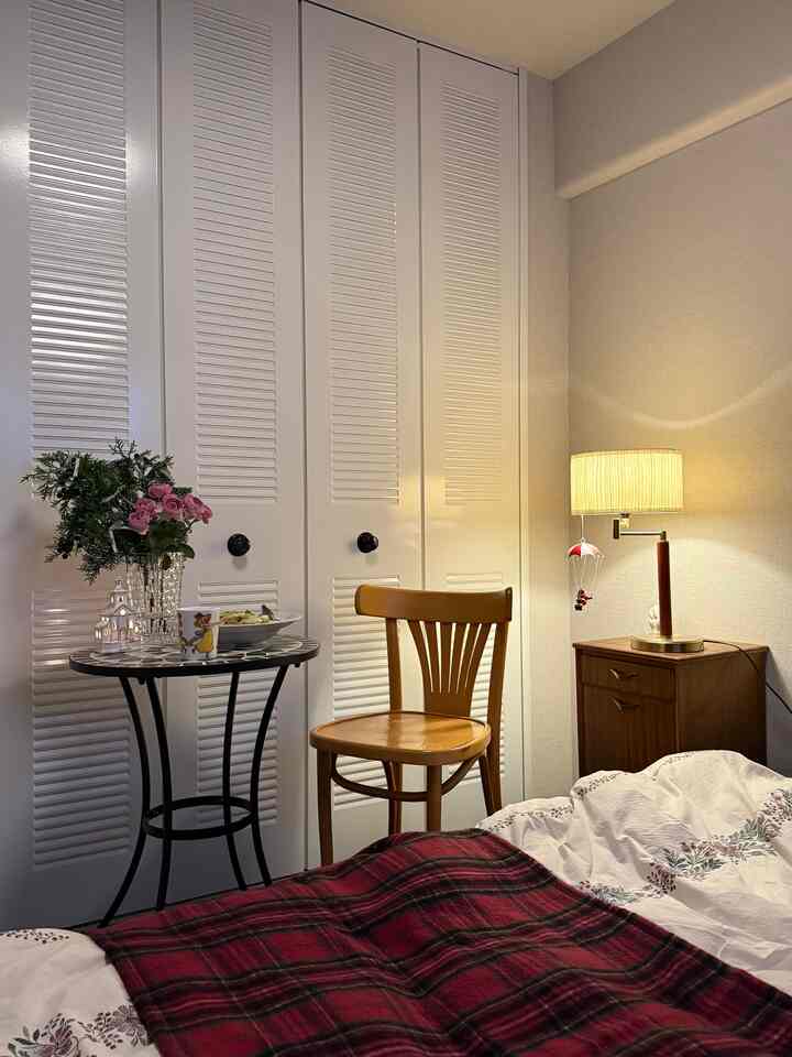 白い壁とブラウンの木製家具が調和する寝室の居心地の良いおうちカフェ空間