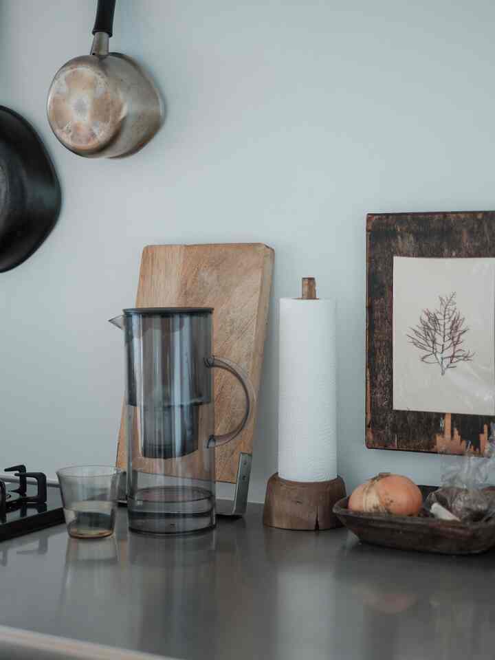 Natural-toned kitchen featuring a wooden cutting board and a paper towel holder creating a simple and cozy atmosphere