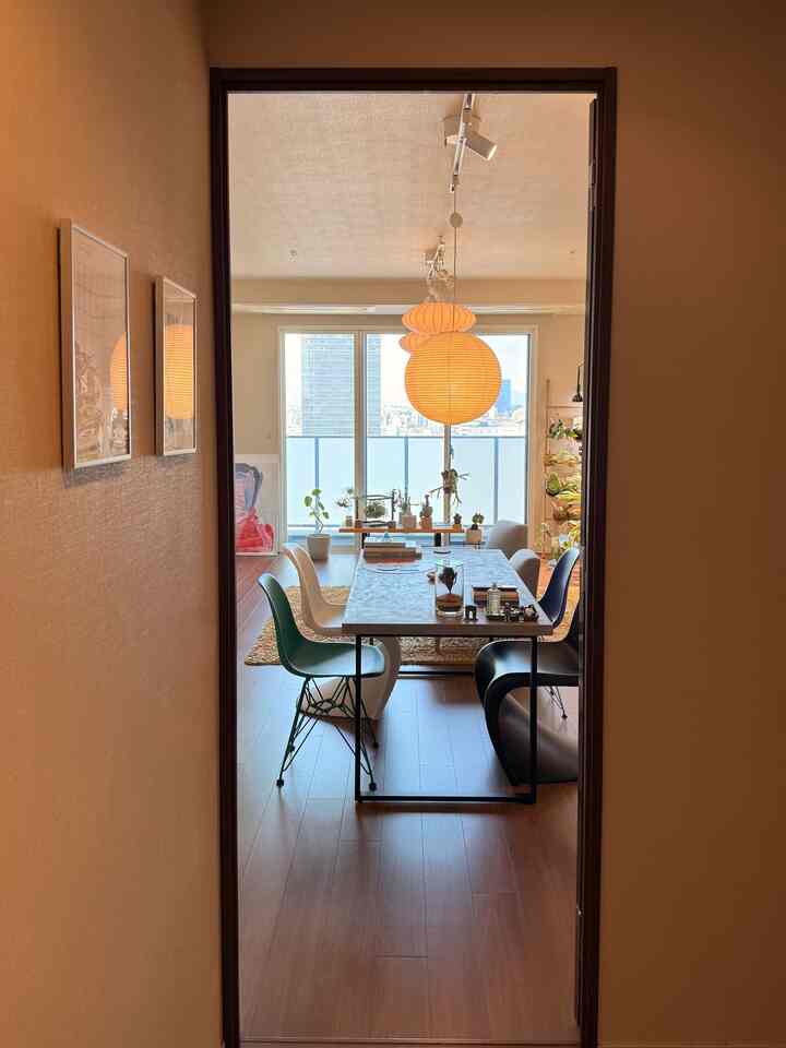 Wood tone flooring and modern furniture in an open living room featuring a round pendant light centrally placed