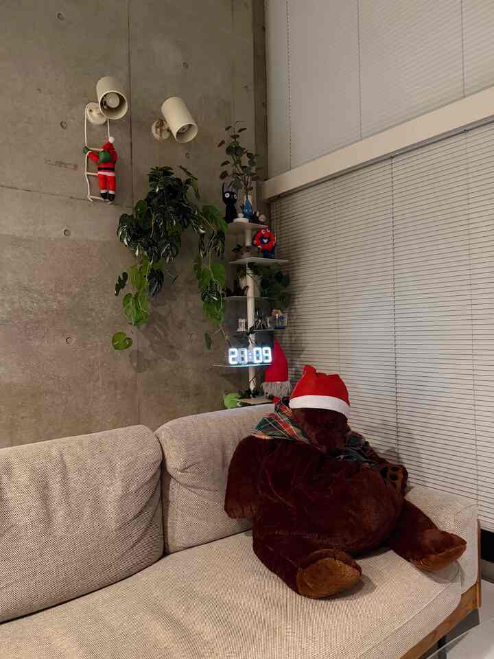 Beige-toned sofa with wall sconces in a Nordic-style living room featuring Christmas decorations and plants creating a natural atmosphere