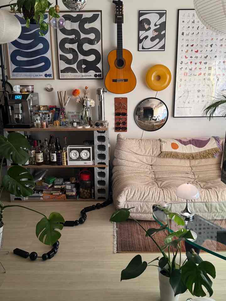 Natural-toned studio living room featuring beige sofa and Monstera plants in a cozy Mid-Century Modern style