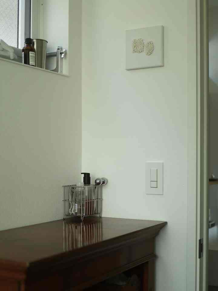 Simple natural dressing room with white walls and a brown vintage dresser