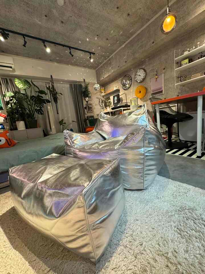 Modern gray-toned small bedroom featuring a silver bean bag sofa and home office setup