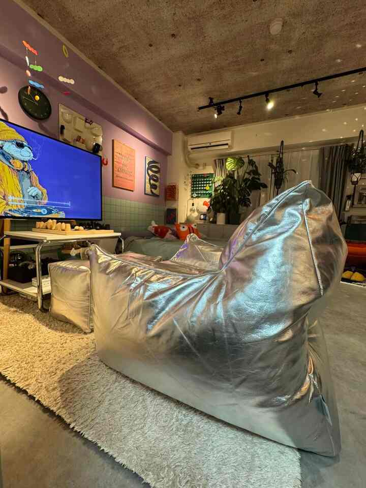 シルバートーンのリビング、中央に大きなビーズクッションソファとベージュのラグが配置されたモダンな印象のインテリア