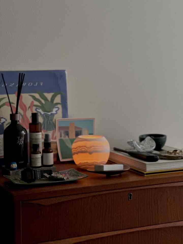 暖かなオレンジ色の灯りがともる木目調の玄関キャビネット、自然でシンプルな雰囲気のあるインテリア