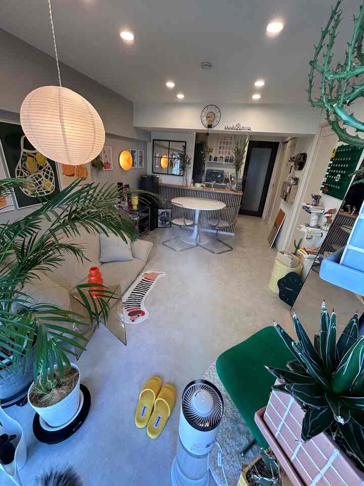 白と緑の色調のリビング、北欧とミッドセンチュリーモダンの家具が配置された印象的な空間