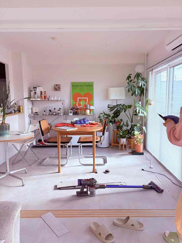 明るいホワイトとグレーのトーンの二人暮らし用ミッドセンチュリーモダンのダイニングルーム、木製テーブルとダイニングチェア、植物が配置された雰囲気のあるインテリア