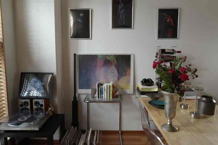 ナチュラルトーンの一人暮らしリビング、花瓶の花とミッドセンチュリーモダン家具が配置された印象的な空間