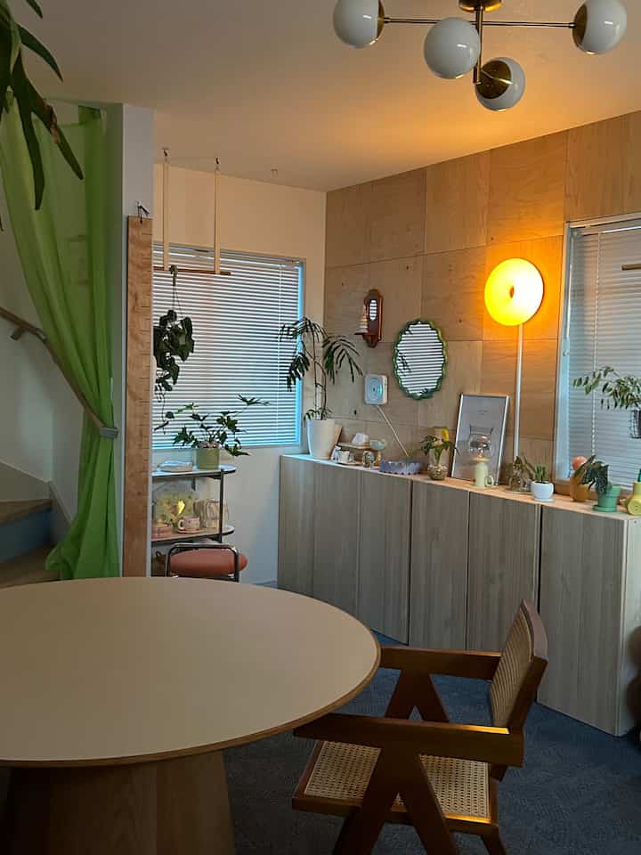 Natural wood-tone wall with assorted plants in a cozy and organized living and dining area