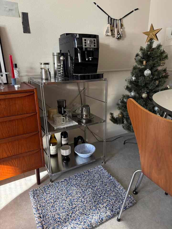 ブラックと木調が調和するダイニング、ステンレス棚にコーヒーマシンと食器類が配置された雰囲気のあるインテリア