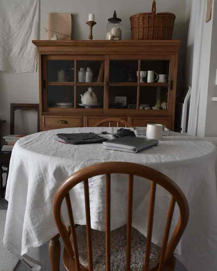 Natural wood-tone dining room featuring round dining table and wooden chairs with a simple atmosphere