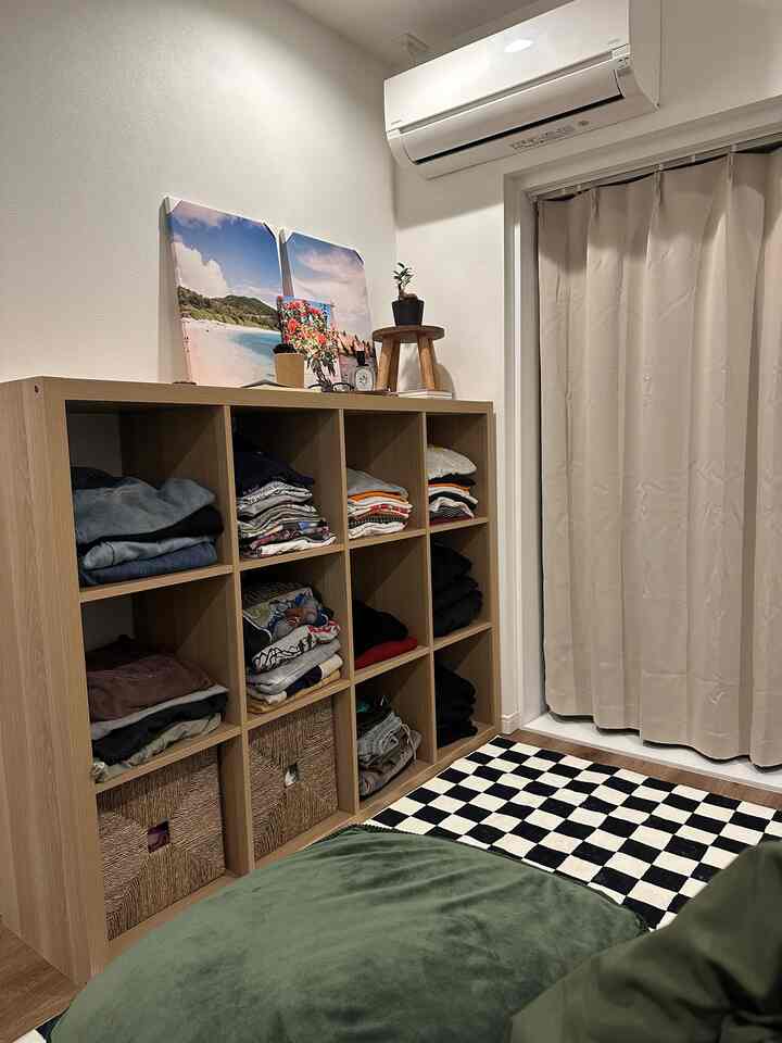 ナチュラルな木目調とグリーンのアクセントがある6畳のワンルーム、収納アイデアが映えるすっきりとした空間