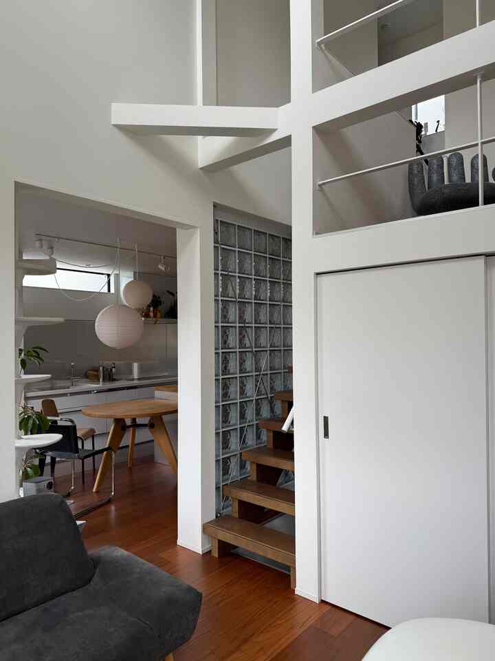 White and wood tone 4.5-tatami mid-century modern living room featuring pendant lights and a cat tower in a cozy setting