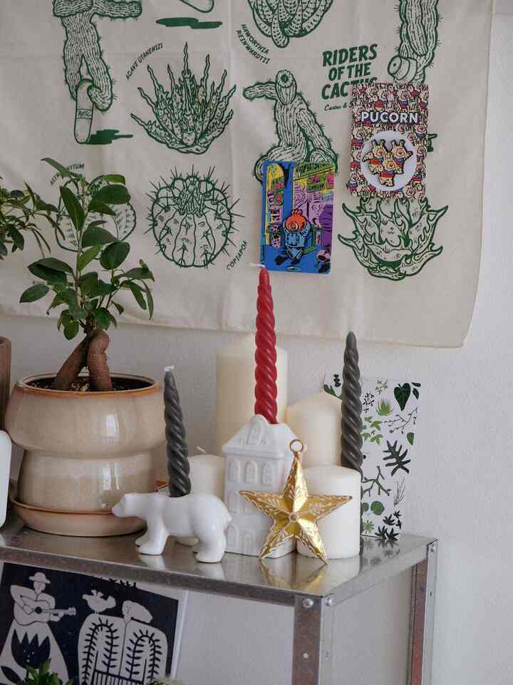 ナチュラルな色調の空間、金色の星の飾りと多彩なキャンドルが置かれた棚がある雰囲気のあるインテリア