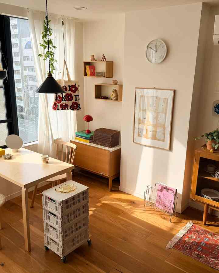 Natural beige and wood-toned dining room with simple Nordic furniture, a wall clock, and plants creating a cozy atmosphere