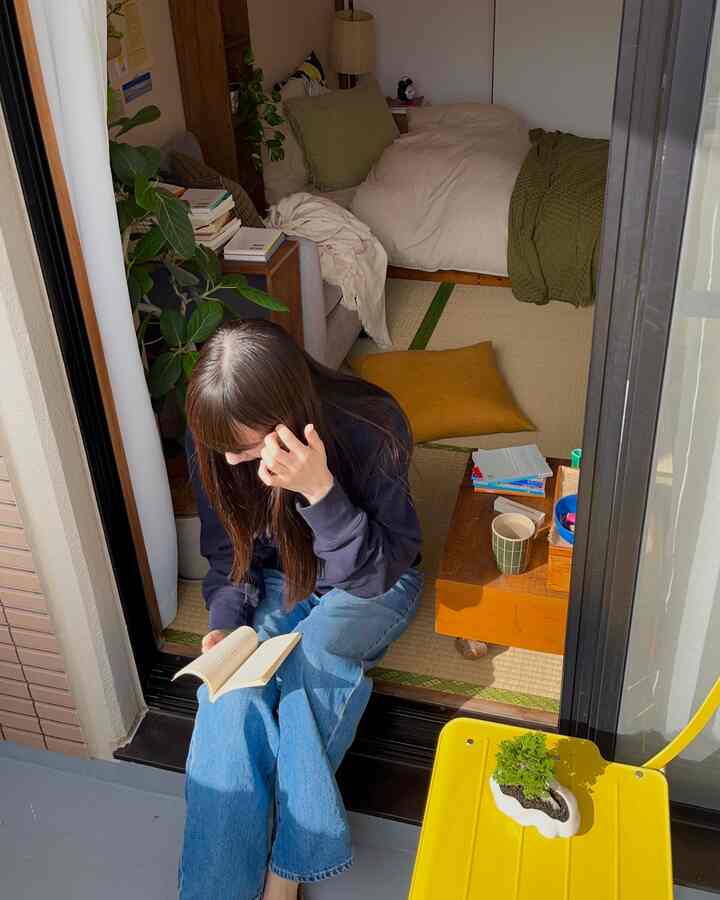 Natural-toned veranda and tatami room featuring a person reading, creating a cozy atmosphere