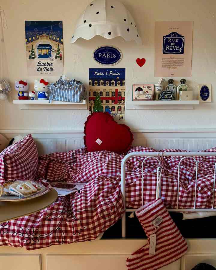 白い壁とベッドフレームに赤のギンガムチェックの寝具とハート型クッションが配置された雰囲気のある寝室