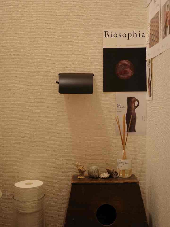 ベージュ色の壁とブラウンの木目調オブジェが配置されたシンプルなトイレの雰囲気あるインテリア