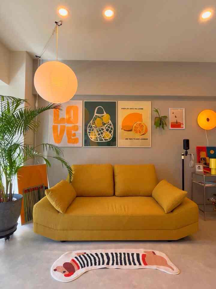 黄色のソファを中心に据えた北欧風のリビング、丸いペンダントライトとフロアランプが配置された雰囲気のある空間