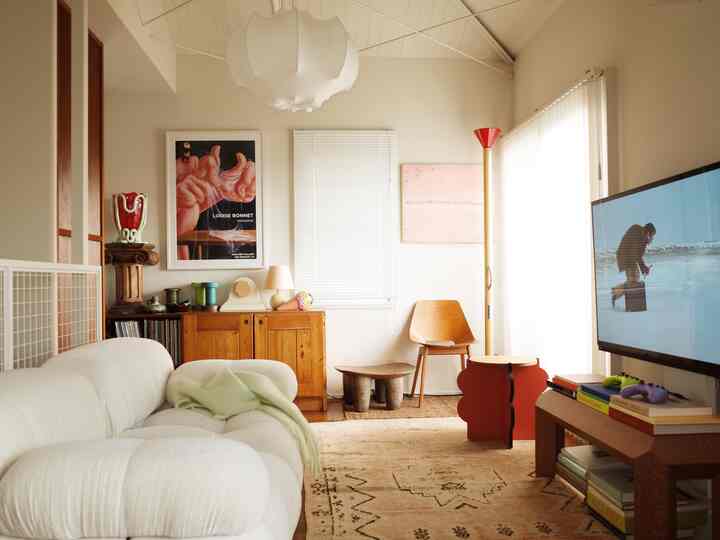 Mid-century modern living room in white and wood tones featuring sofa and floor lamp with a warm atmosphere