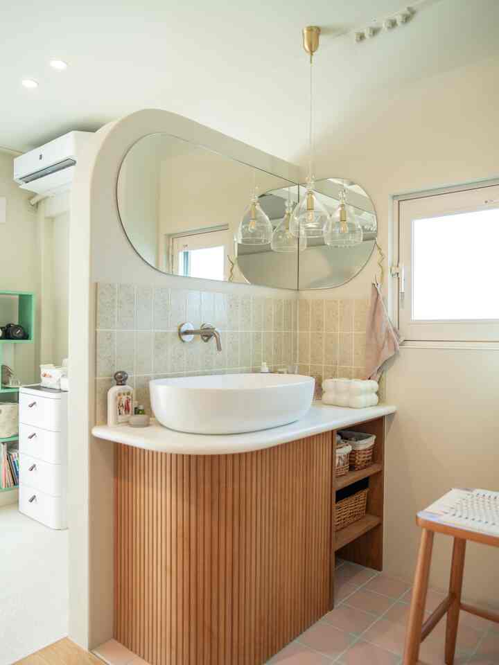 A natural-toned bathroom space featuring a wooden vanity and modern sink with clean, minimalistic design