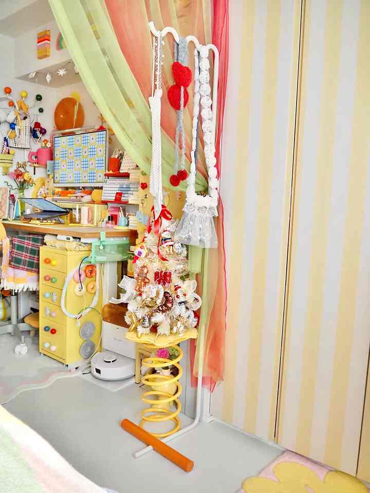 黄色とパステル調が調和した一人暮らしのホームオフィス、小物や収納が配置された雰囲気のあるインテリア