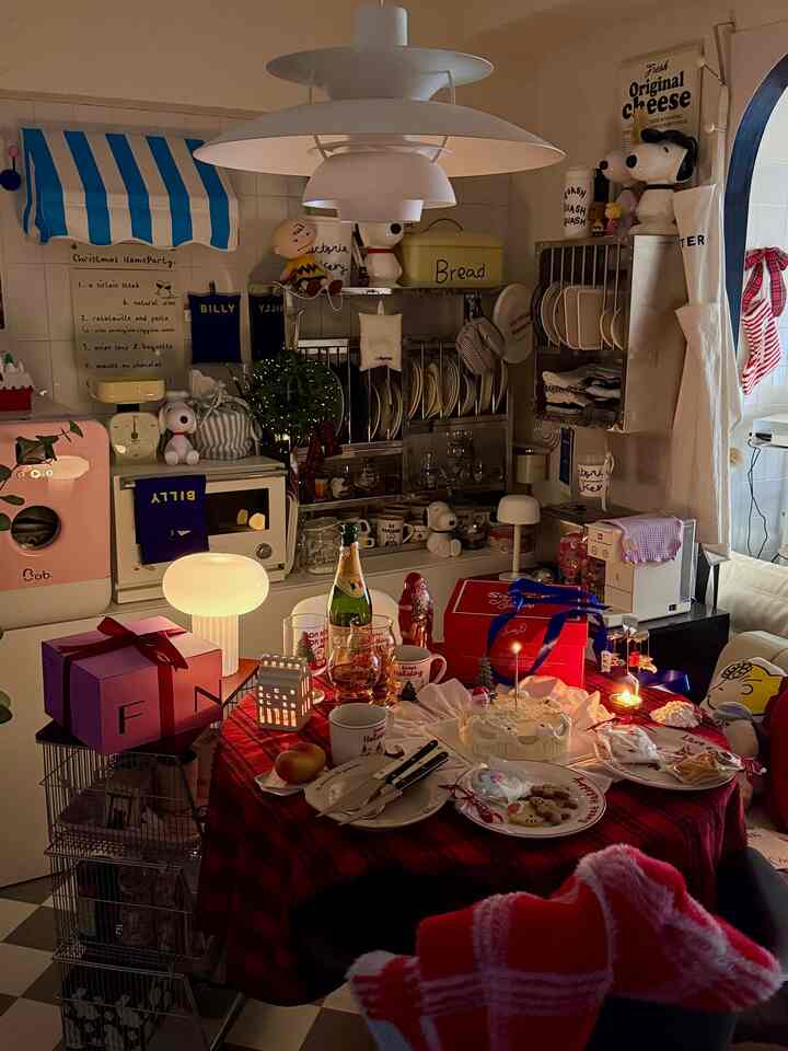赤と白のトーンのキッチン空間、クリスマスのホームパーティーテーブルと多彩なキッチン用品が配置された雰囲気のあるインテリア