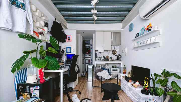 白と茶色の色調のワンルーム、デスクとオフィスチェアが配置されたシンプルモダンなインテリア