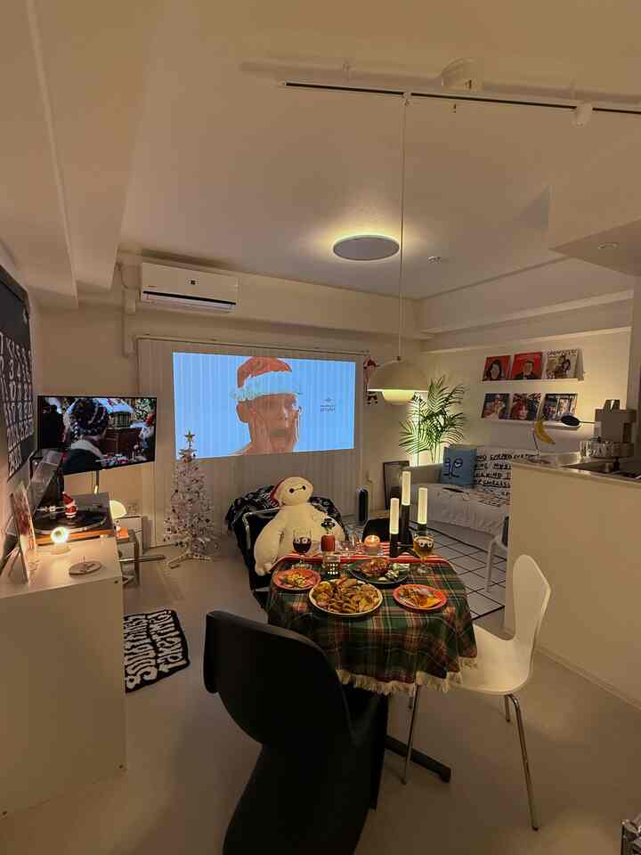 White-tone living and dining room featuring Christmas decorations and a table set with home party food in a cozy atmosphere