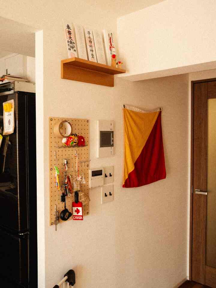 Bright beige-toned entrance featuring a pegboard and wooden shelf with a cozy atmosphere