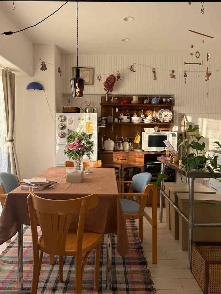 ナチュラルカラーのコンパクトなダイニングキッチン、ヴィンテージ家具とテーブルが温かみのある雰囲気を醸し出すインテリア