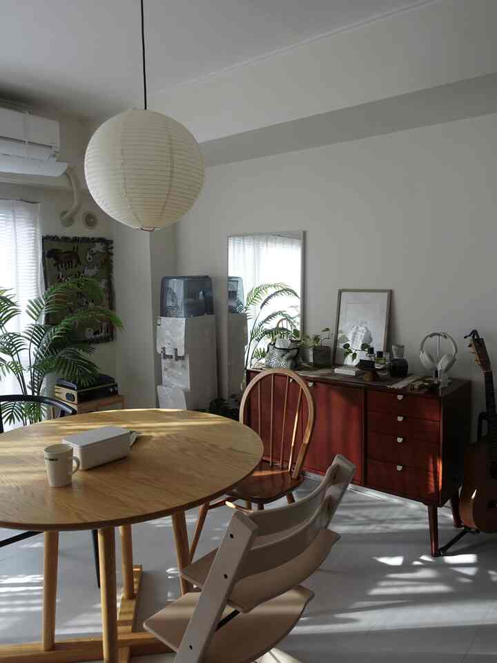 Bright wood tone and white two-person dining room featuring simple modern furniture and a pendant light