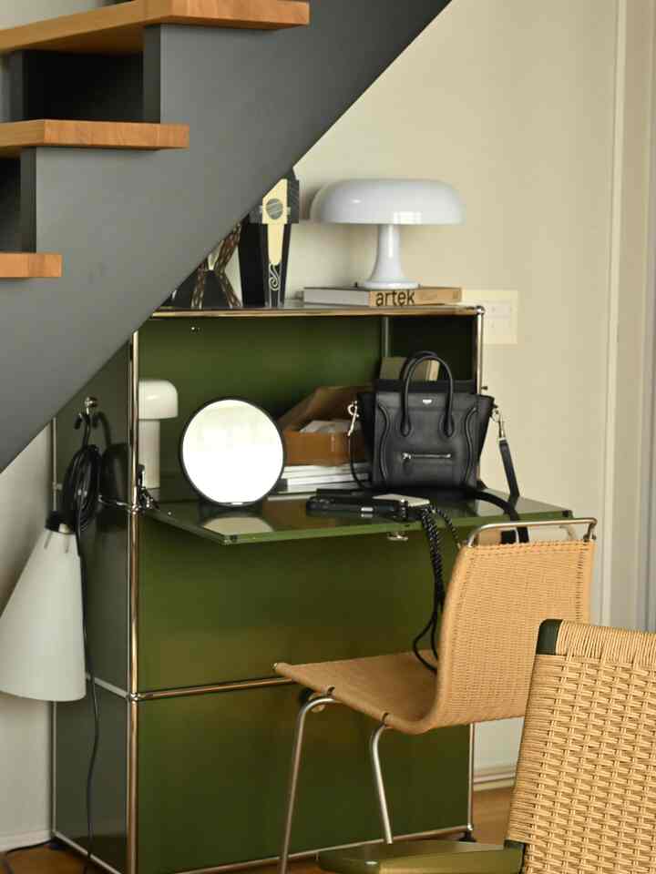 Compact home office space featuring a green USM cabinet and woven chairs, offering a practical and clean atmosphere