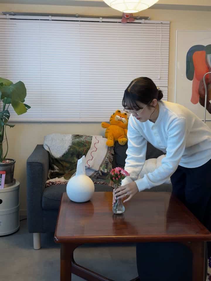 ナチュラルな色調の1LDKリビング、ミッドセンチュリーモダンのソファと木製コーヒーテーブルが配置された落ち着いた空間