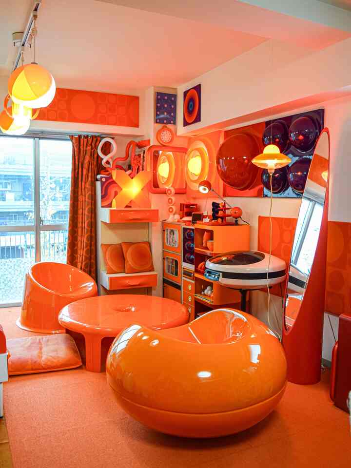 Orange-toned living room featuring rounded furniture and wall decorations in a vibrant retro interior space