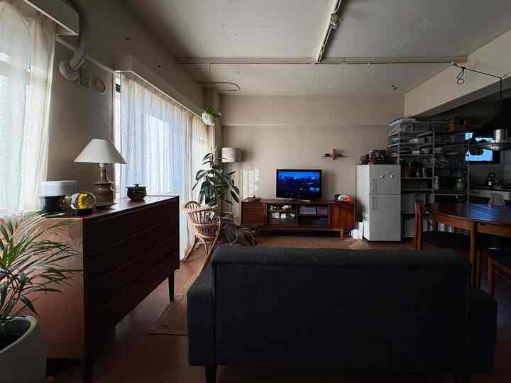 Natural and brown-toned studio living room featuring rattan chair and vintage furniture in a cozy space