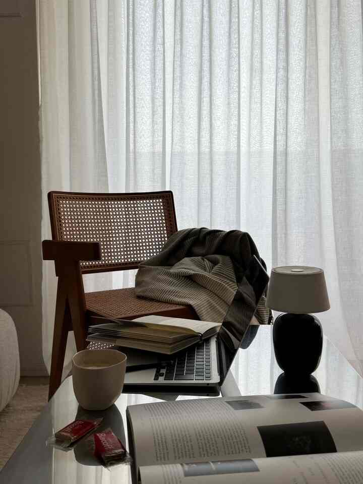 ベージュ調のリビング、木製の椅子とローテーブルが配置された自然でモダンな作業スペース