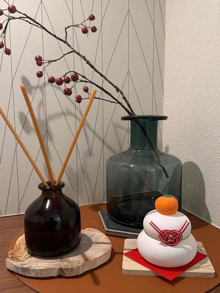 A natural color entrance space featuring vases, diffuser, and traditional Japanese kagami mochi ornament creating a tasteful atmosphere