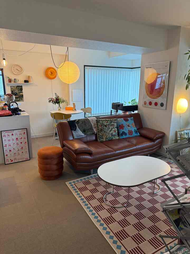 Natural modern tone living room featuring a brown sofa, white coffee table, and patterned rug in a cozy space