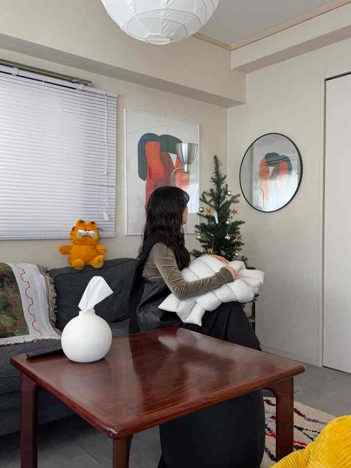 ナチュラルトーンの12畳リビング、ダークソファと木製コーヒーテーブルが配置された温かみのある空間