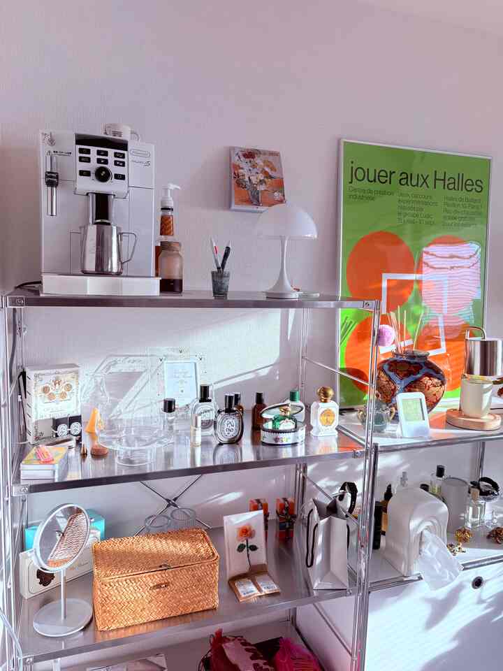 ライトグレーのスチールラックとコーヒーマシン、ナチュラル素材のバスケットが配置されたミッドセンチュリーモダンな二人暮らしの空間