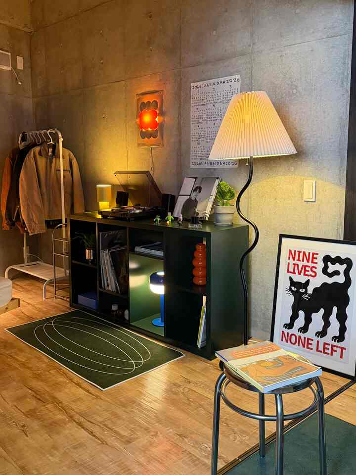 Vintage style living room with warm ambient lighting, plants, and graphic posters creating a cozy atmosphere