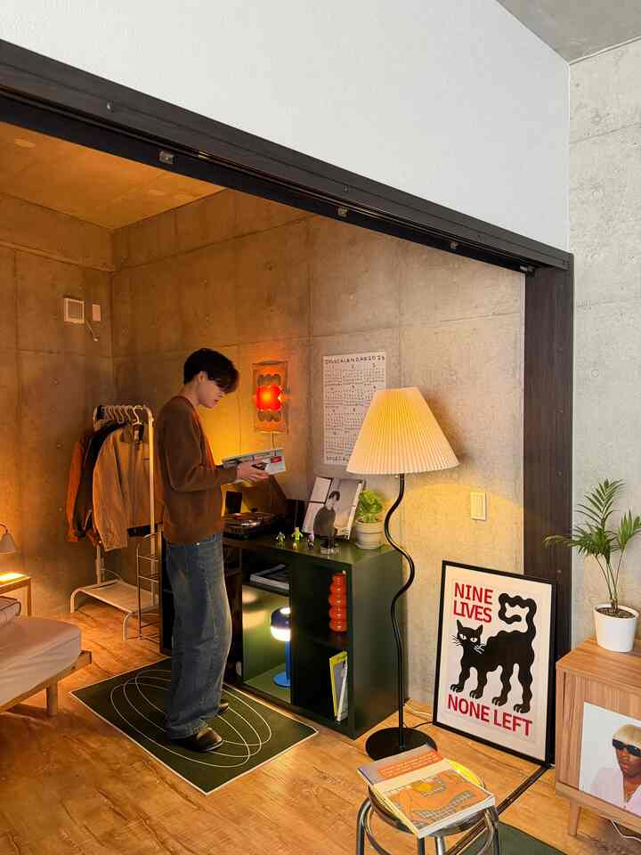 ナチュラルな色調とモダンな雰囲気の寝室、フロアランプと植物が配置された落ち着いたインテリア