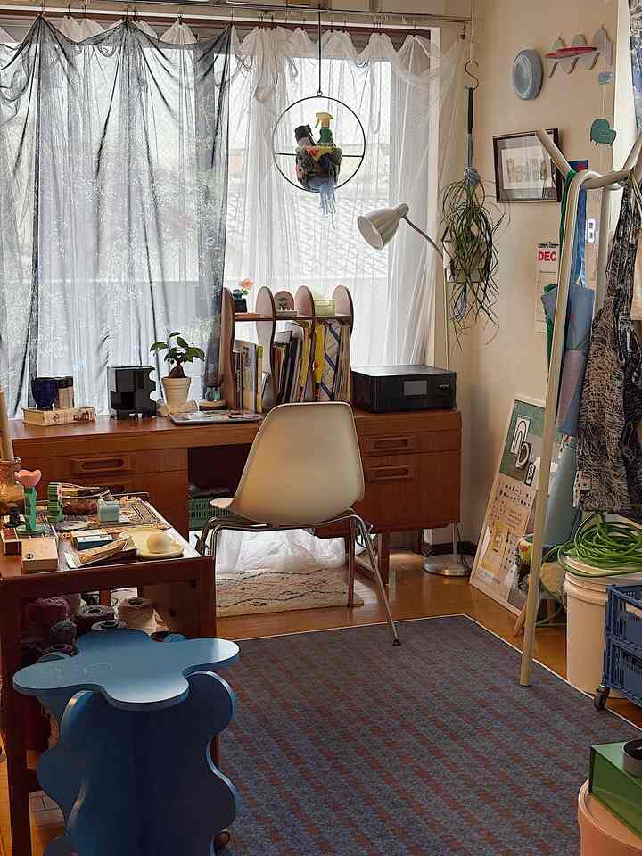 暖かい木目調とブルーのラグが調和する北欧風のホームオフィス、実用的なデスクと椅子が配置された落ち着いた空間