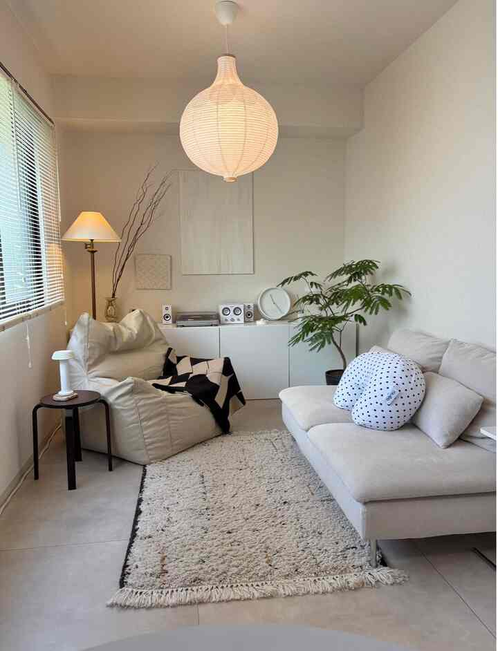 Beige and white toned living room featuring sofa, bean bag, and natural plants creating a cozy natural interior